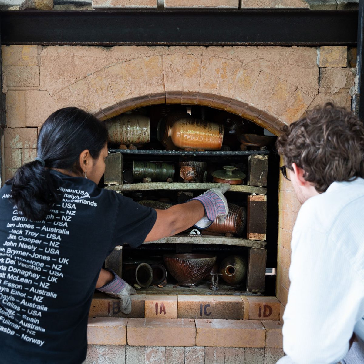 Potter loading ceramics into a kiln.