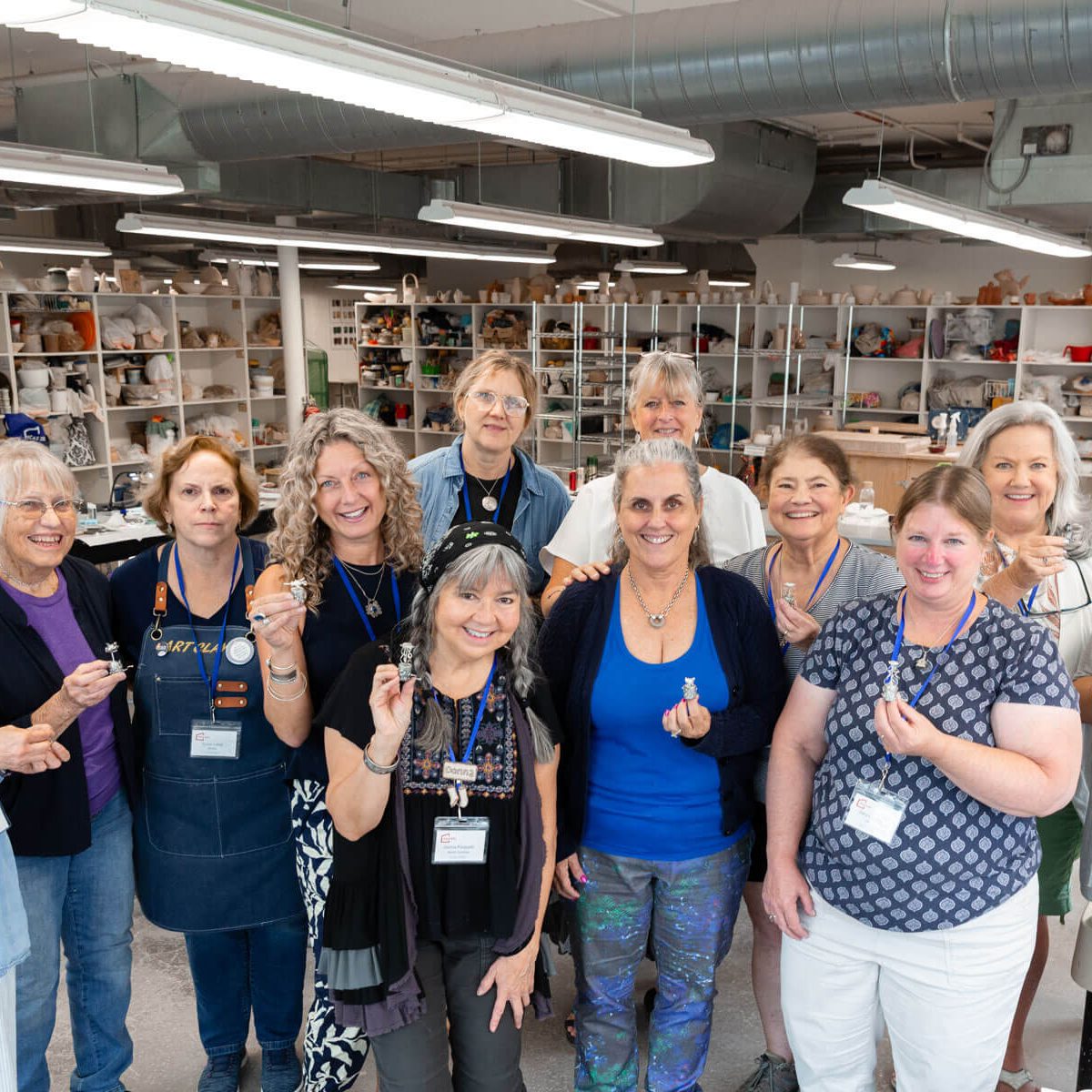 A group of students and instructors posing together in a studio class.