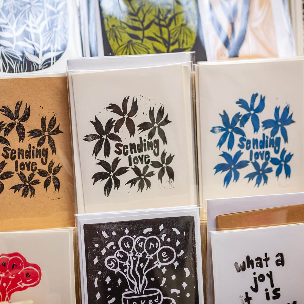 A display of handmade greeting cards featuring printed floral and graphic designs.