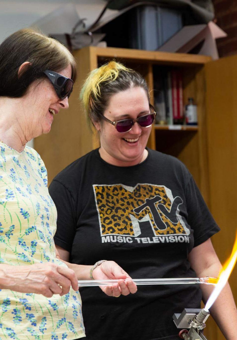 Two women chatting and smiling together in a studio setting.