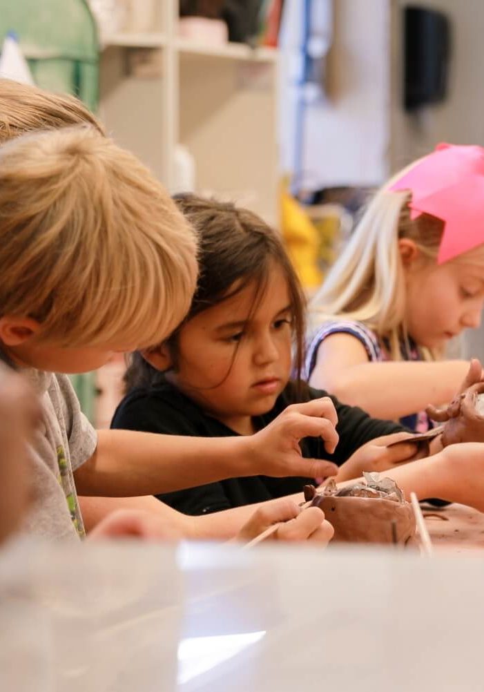 A group of young children doing crafts together at a table.